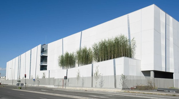 Bâtiment contemporain à façade blanche avec végétation intégrée, illustrant une architecture durable et épurée.